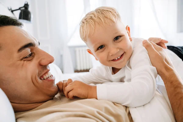 Молодий Білий Батько Розважається Грає Своїм Сином Ліжку Вдома — стокове фото