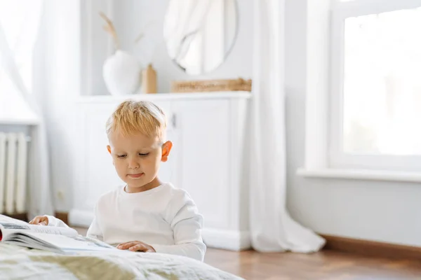 White Blonde Boy Wearing Home Clothes Reading Book Indoors — Stockfoto