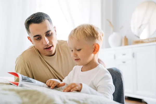 Giovane Padre Bianco Leggere Libro Con Suo Figlio Mentre Seduto — Foto Stock