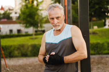 Gri, boks bandajlı son sınıf öğrencisi spor alanında çalışıyor.