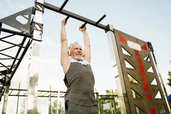 Grey Senior Sportsman Listening Music While Working Out Sports Ground — Foto Stock