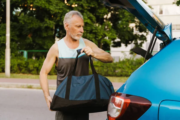 Grey Senior Sportsman Getting Bag Out Trunk Outdoors — Stock Photo, Image