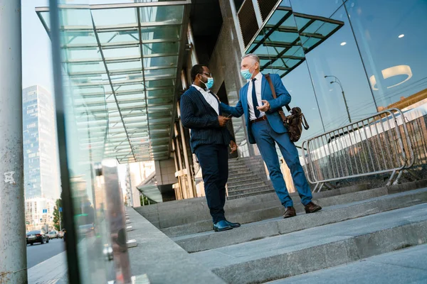 Multiracial Men Face Mask Talking Gesturing While Going Stairs Outdoors — стоковое фото