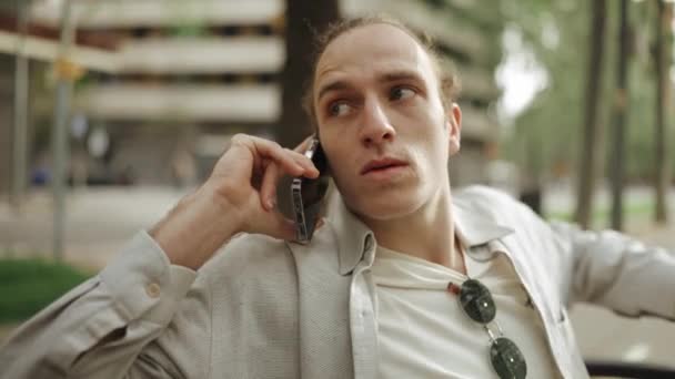 Displeased Curly Haired Man Talking Phone Outdoors — Video