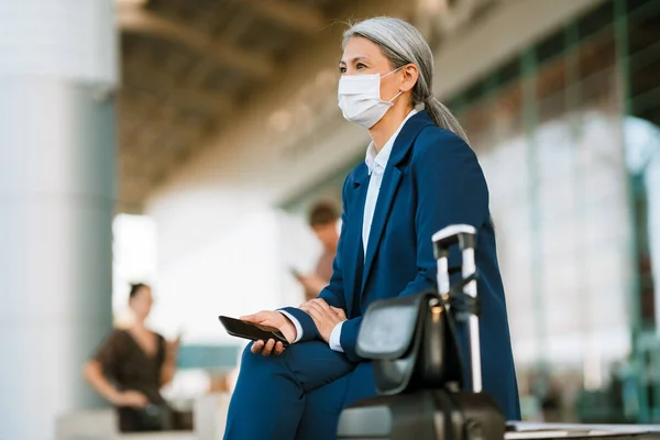 Grey Asian Woman Face Mask Using Cellphone While Sitting Bench — Foto Stock