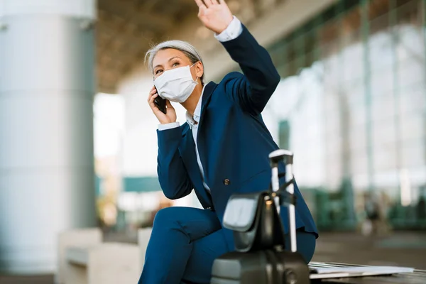 Grey Woman Face Mask Waving Hand While Talking Cellphone Airport — Foto Stock