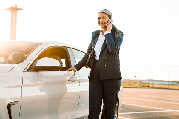 Mature Asian Businesswoman Smiling Talking Cellphone While Standing Car — Fotografia de Stock