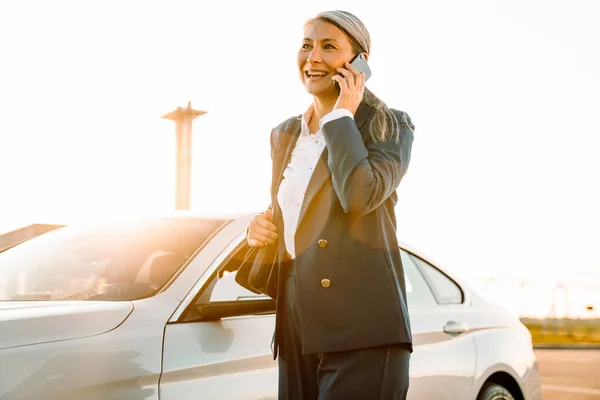 Mature Asian Businesswoman Smiling Talking Cellphone While Standing Car — Stockfoto