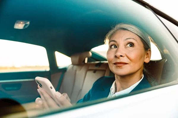 Gammal Asiatisk Affärskvinna Som Använder Mobiltelefon När Går Bil — Stockfoto