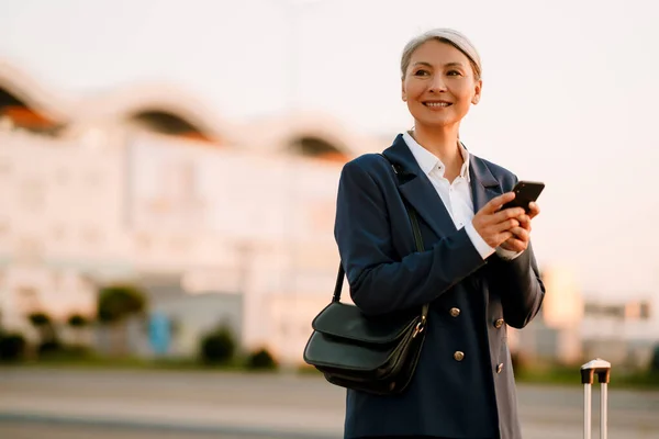 Grey Asian Woman Smiling While Using Mobile Phone Outdoors — Foto de Stock