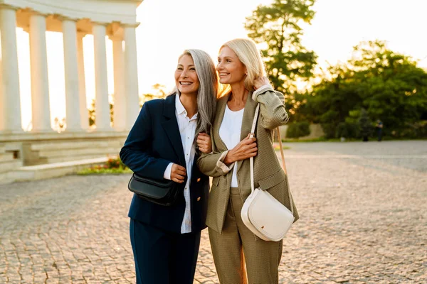 Mature Multiracial Businesswomen Smiling Hugging Walking Outdoors — 스톡 사진