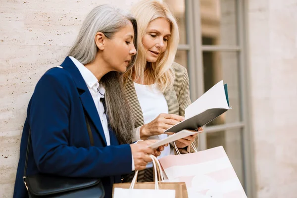 Olgun, çok kültürlü kadınlar dışarıda alışveriş yapmaktan bahsediyorlar.