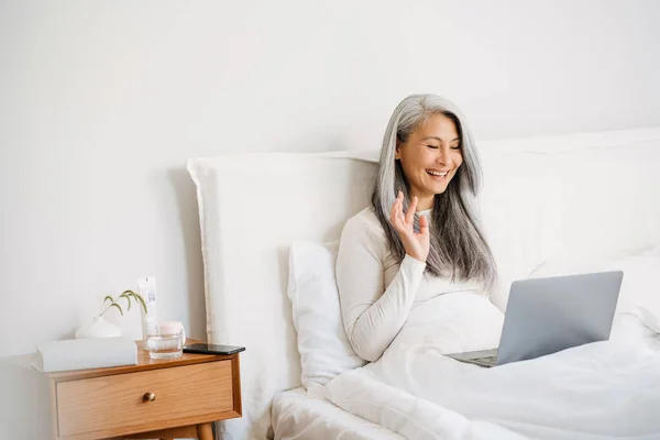 Grey Asian Woman Gesturing Using Laptop While Sitting Bed Sleep — Foto de Stock