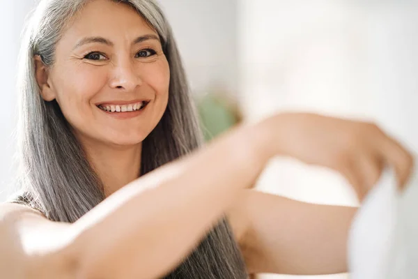 Зріла Азіатська Жінка Сірим Волоссям Посміхається Дивиться Камеру Вдома — стокове фото
