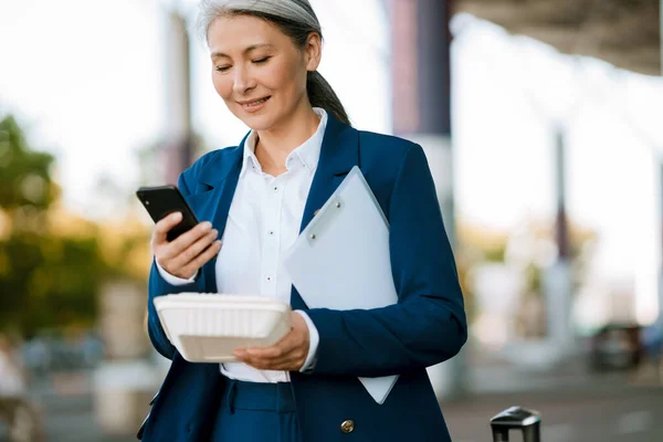 Grey Asian Woman Holding Food Box Using Mobile Phone Airport — Foto de Stock