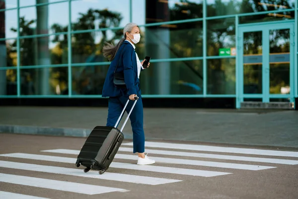 Grey Woman Face Mask Using Cellphone While Walking Zebra Crossing — стоковое фото