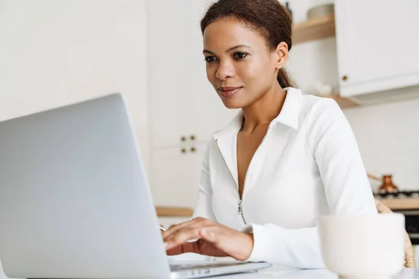 Black Woman Smiling While Working Laptop Kitchen Home — Fotografia de Stock