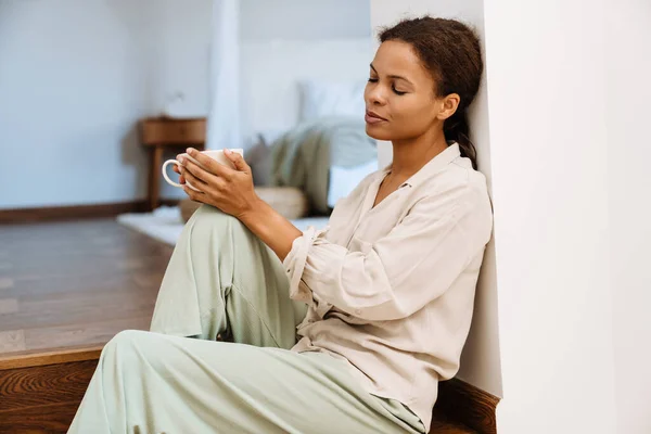 茶を飲みながら家の階段に座る黒人女性 — ストック写真