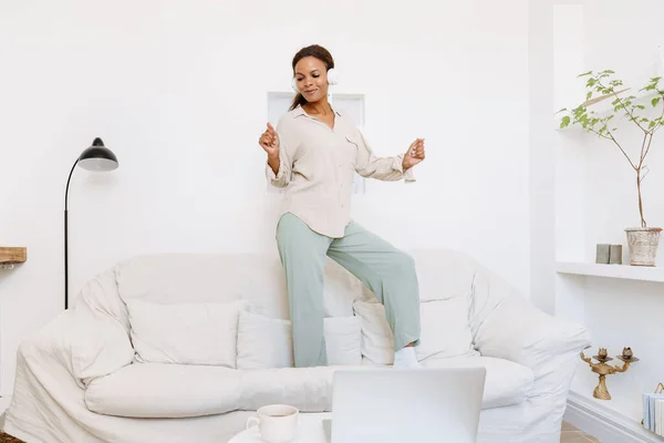 Young Black Woman Dancing Couch While Listening Music Home — Stock Fotó