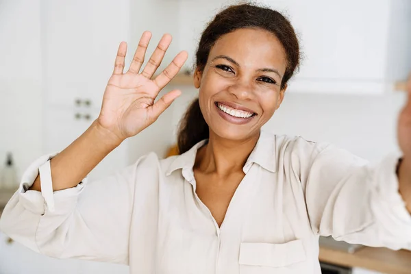 年轻的黑人妇女在家里给自己拍照时 脸上挂着笑容和手势 — 图库照片