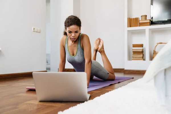 Young Black Woman Using Laptop Yoga Practice Home — стоковое фото