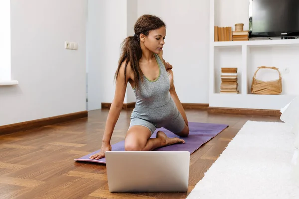 Young Black Woman Using Laptop Yoga Practice Home — стоковое фото