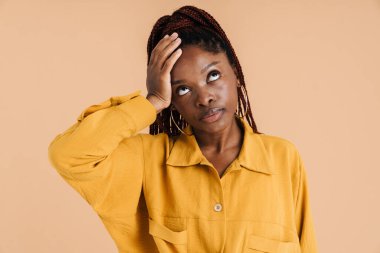 Başı ağrıyan, başı bej renkli genç bir kadın.