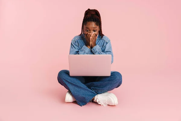 Black Woman Expressing Surprise Using Laptop While Sitting Floor Isolated — Stock Photo, Image