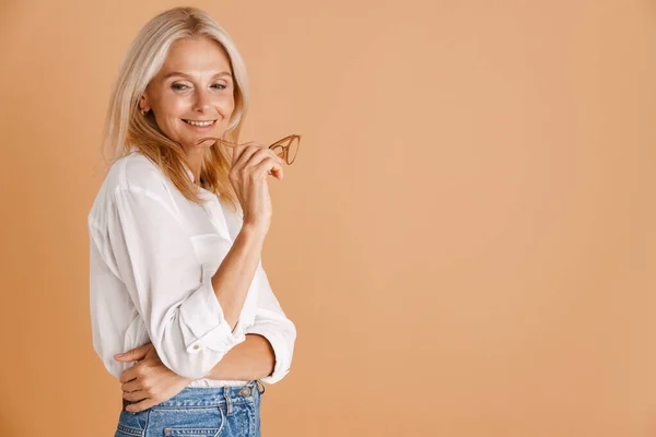 Mature Woman Eyeglasses Smiling Holding Eyeglasses Isolated Beige Background — 스톡 사진