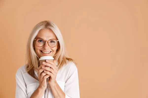 Mature Woman Eyeglasses Smiling While Drinking Coffee Isolated Beige Background — Stockfoto