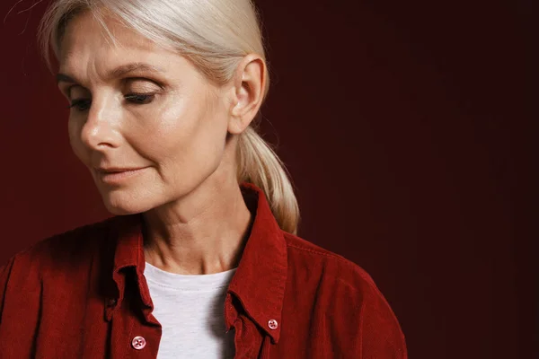 Mature Blonde Woman Wearing Shirt Posing Looking Downward Isolated Red — 스톡 사진