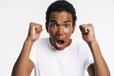 Genç siyahi adam beyaz duvarın üzerinden izole edilmiş kameraya bağırıyor.