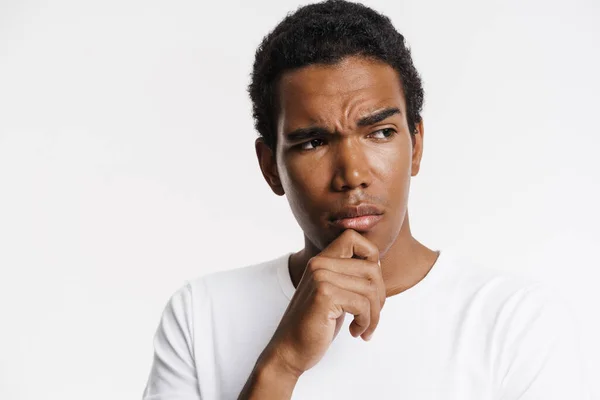 Young Black Man Looking Aside Frowning While Holding His Chin — Stock Photo, Image