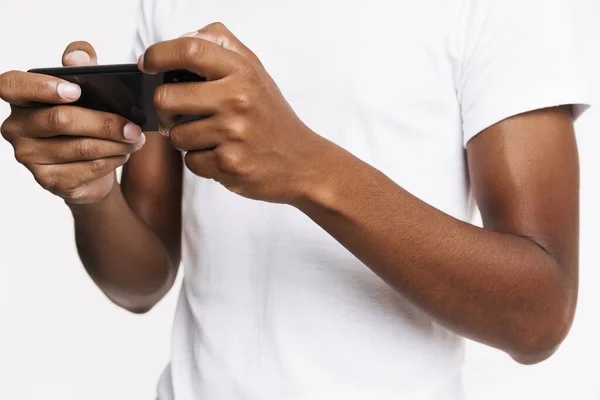 Young Black Man Playing Online Game Mobile Phone Isolated White — Zdjęcie stockowe