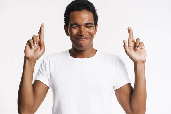 Young Black Man Smiling While Holding Fingers Crossed Good Luck — стоковое фото