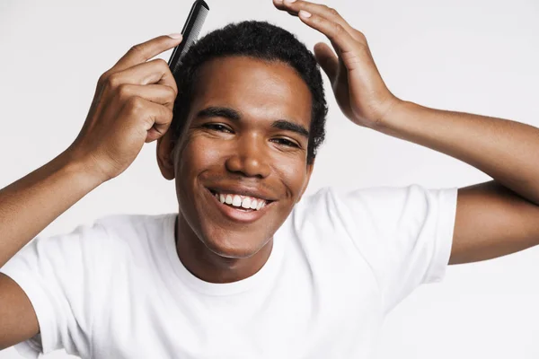 Young Black Man Smiling Camera While Combing His Hair Isolated — Stockfoto