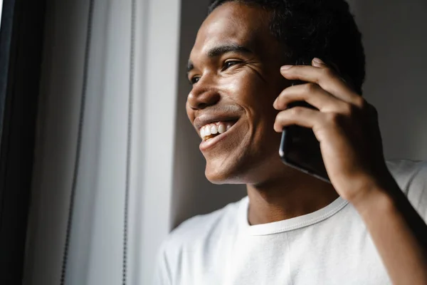 Young Black Man Smiling Talking Cellphone While Leaning Wall Indoors — Stock Fotó