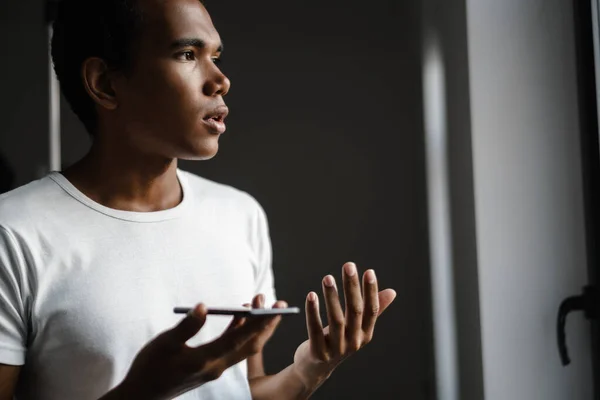Egy Fiatal Fekete Férfi Mobilon Beszél Miközben Ablakot Nézi — Stock Fotó