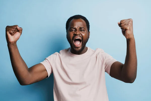 Black Bristle Man Screaming While Making Winner Gesture Isolated Blue — Stockfoto