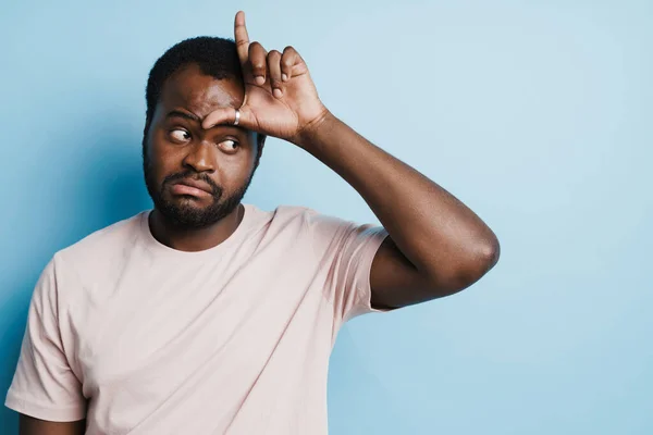 Black Confused Man Shirt Grimacing While Pointing Finger Upward Isolated — Stockfoto