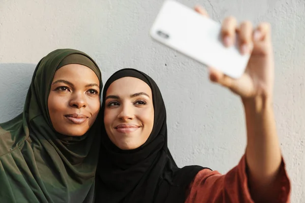Multiracial Muslim Women Smiling While Taking Selfie Photo Cellphone Outdoors — Stockfoto