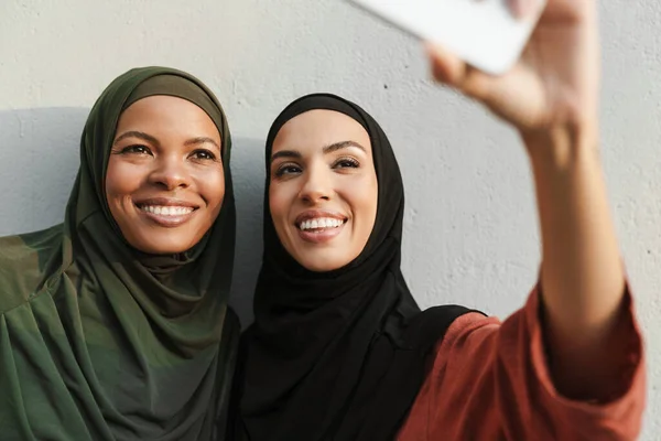 Multiracial Muslim Women Smiling While Taking Selfie Photo Cellphone Outdoors — Stockfoto