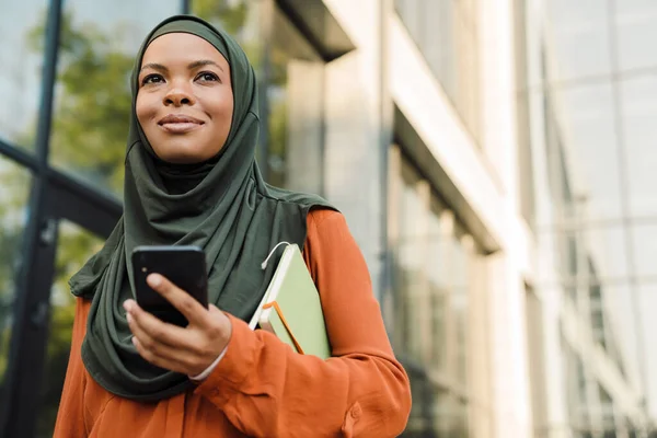 Černá Muslimská Žena Pomocí Mobilního Telefonu Během Chůze Ulici Města — Stock fotografie