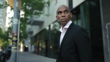 Sokakta yürüyen konsantre Afrikalı işadamı