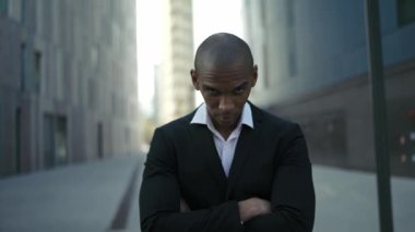Pozitif Afrikalı iş adamı sokakta kameraya bakıyor.