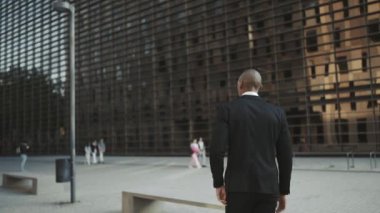 Sokakta telefonla yazarken, bankta yürüyen ve oturan Afrikalı işadamlarının arka plan görüntüsü