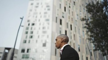 Ciddi bir Afrikalı işadamı açık havaya bakıyor.