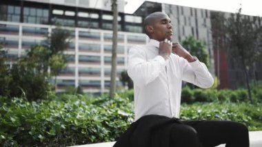 Yorgun Afrikalı işadamı dışarıda bankta dinleniyor.