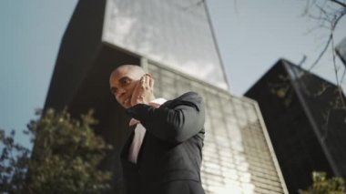 Dışarıda kulaklıkla konuşan neşeli Afrikalı işadamı