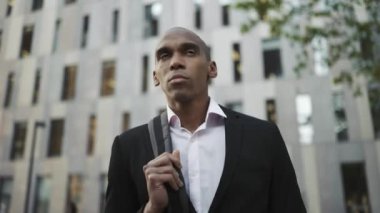 Düşünceli Afrikalı işadamı şehirde yürüyor